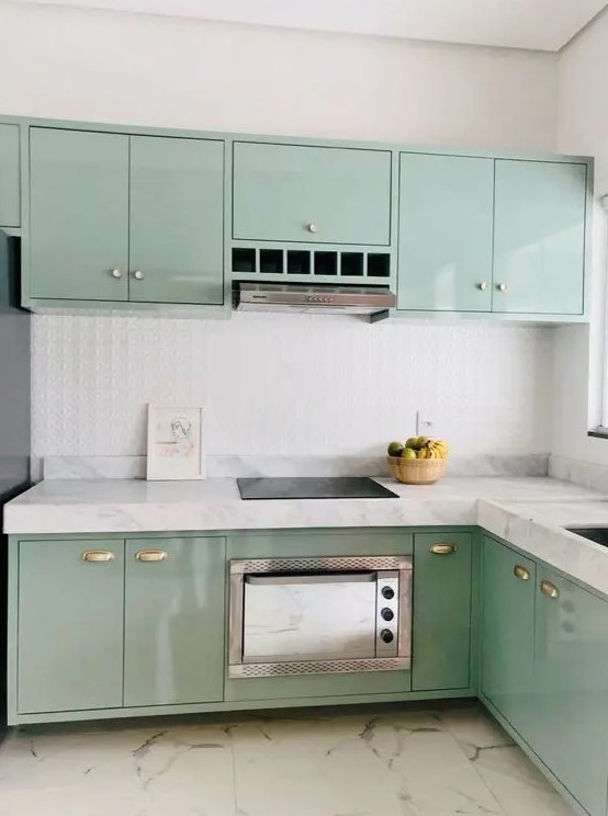 a glossy mint blue kitchen with flat panel cabinets, white stone countertops and a white embossed tile backsplash