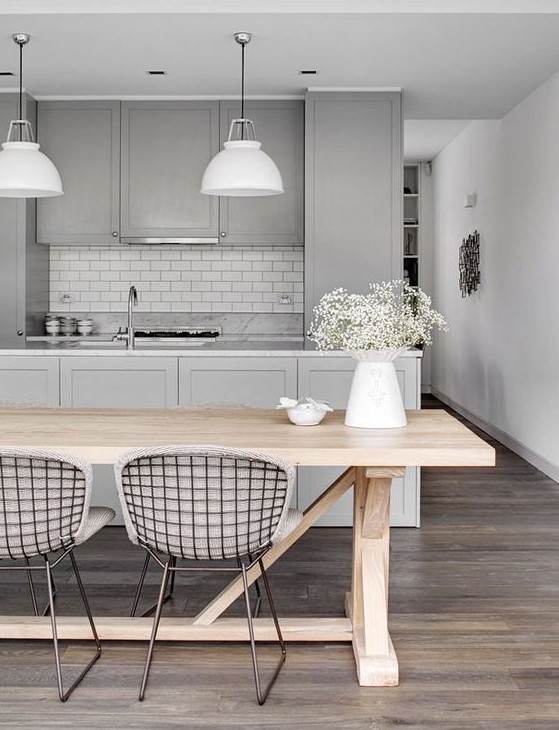 a grey kitchen with shaker cabinets, a white tile backsplash, white pendant lamps, white countertops is chic and cozy