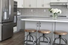 a mid-century modern kitchen with dove grey lower cabinets, white upper ones, a grey tile backsplash and a grey kitchen island