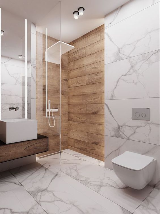 a minimalist bathroom with white marble tiles and wood look tiles in the shower space for a warm touch