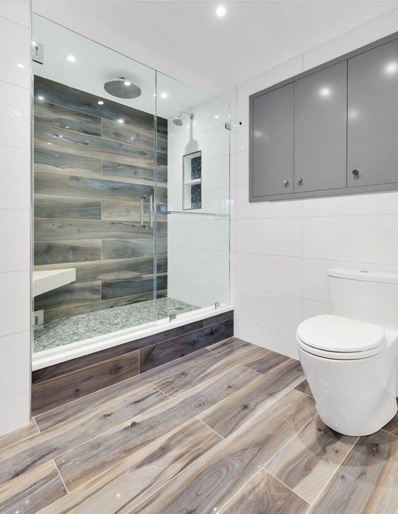 a minimalist bathroom with white tiles and wood look tiles in the shower and on the floor for a warm and soft feel
