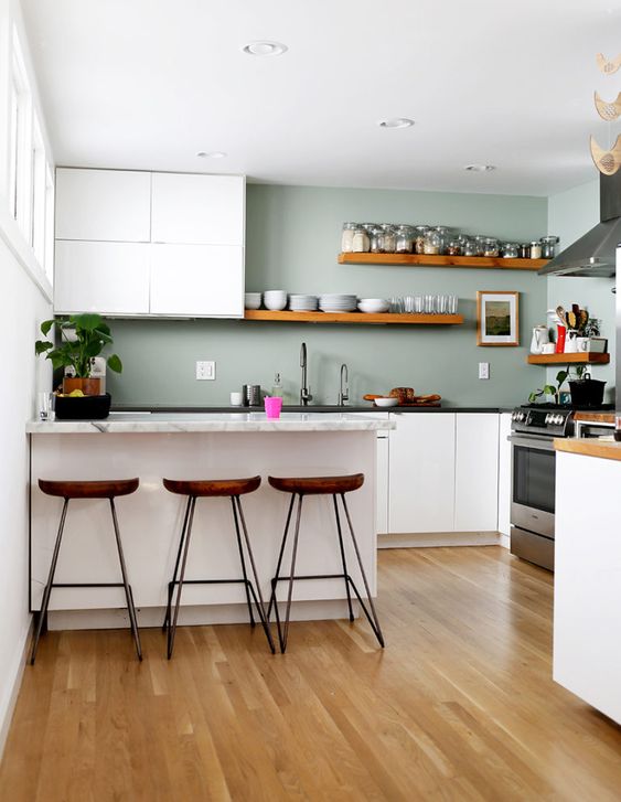 a minimalist kitchen with white cabinets, pale green walls, stone countertops and wooden shelves and stools a minimalist kitchen with white cabinets, pale green walls, stone countertops and wooden shelves and stools