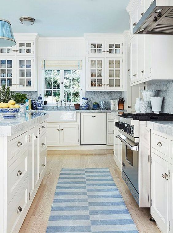 a neutral traditional kitchen with blue countertops and a backsplash, rugs and lamps for a touch of color