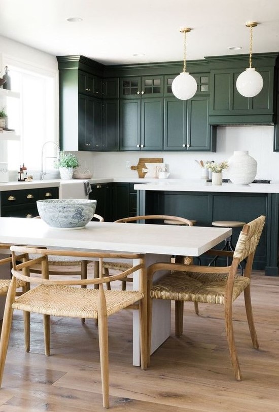 a stylish dark green kitchen with shaker cabinets, white quartz countertops and a backsplash plus pendant lamps on chain