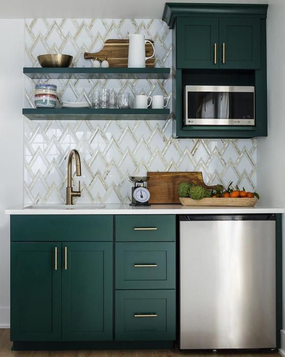 a stylish kitchen with hunter green cabinets, a zig-zag tile backplash and touches of gold for a chic look