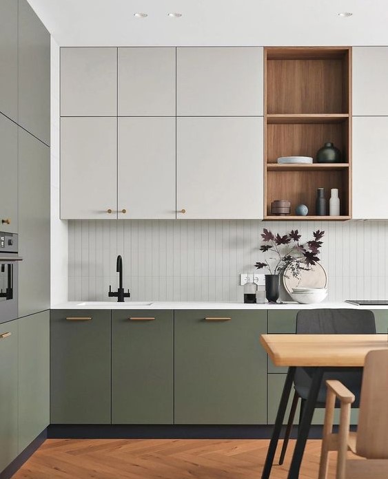 a stylish modern kitchen with white and green cabinets, open stained shelves, a white tile backsplash and white countertops, black fixtures