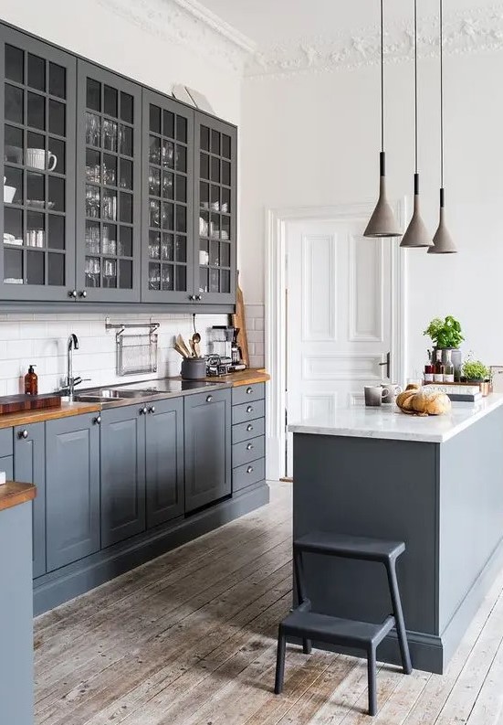 a vintage graphite grey kitchen with whitewashed wooden floors, wooden countertops and white walls to make it look fresher