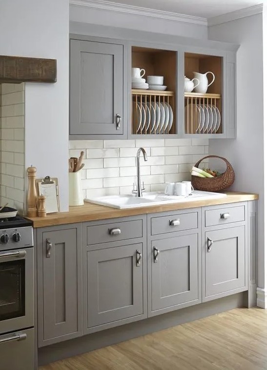 a vintage grey kitchen is softened with wooden countertops and a subway tile backsplash makes it more eye-catchy