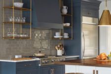 an elegant vintage blue kitchen with a grey subway tile backsplash and touches of gold and natural wood here and there
