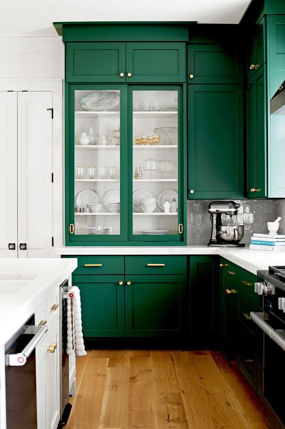 an emerald kitchen with white walls and countertops plus some fold fixture to bring timeless elegance to the space
