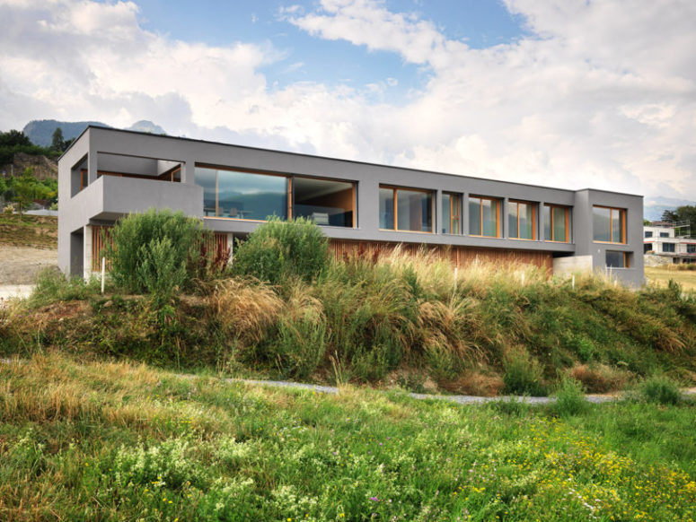 This beautiful linear house is called ROFR, it's built of concrete on Swiss slopes and the seismic activity was considered while building the house