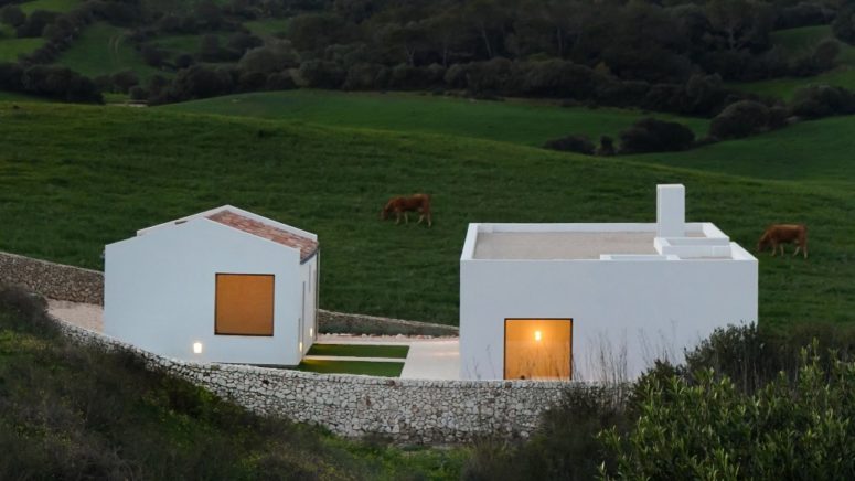 This minimalist dwelling is organized into 2 white volumes with windows and openings to connect them to outdoors