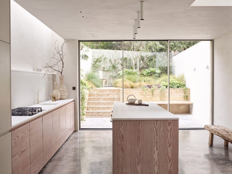 The kitchen is peaceful and neutral, the cabinets are only lower ones, lots of white surfaces create a calm feel, and a glazed door brings much natural light The kitchen is peaceful and neutral, the cabinets are only lower ones, lots of white surfaces create a calm feel, and a glazed door brings much natural light