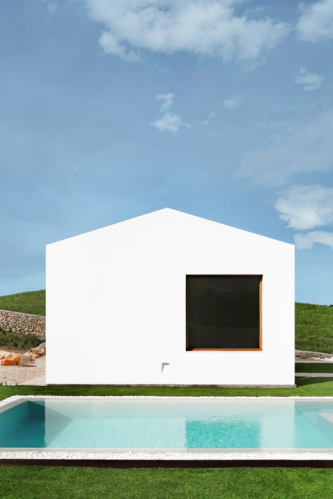 There's a cool minimal pool outside, it's surrounded with white pebbles and green grass