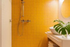 02 a bright bathroom with a super bold sunny yellow tile wall, wooden beams and a large palm leaf