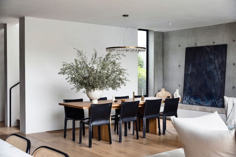 The formal dining space is done with a wooden table and black leather chairs plus a crystal chandelier The formal dining space is done with a wooden table and black leather chairs plus a crystal chandelier