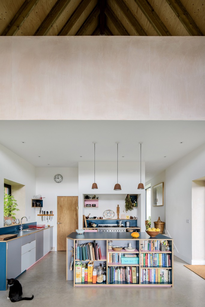 The indoor spaces are modern and chic, with white walls, blue and grey furniture, pendant lamps and greenery