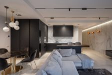 03 The kitchen is sleek and black, with a marble wall, and the dining space is done with a black marble table to echo with it