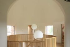 04 On the first floor, a double height living room is framed by the arched geometry of the intersection of two cones