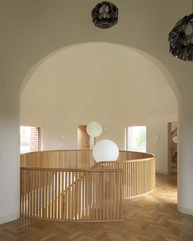 On the first floor, a double height living room is framed by the arched geometry of the intersection of two cones