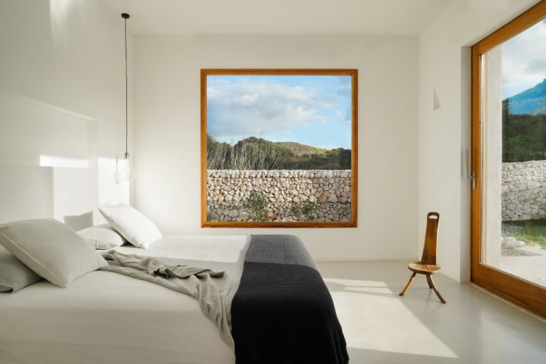 The bedroom is white, too, with a comfy bed, large windows and literally no furniture