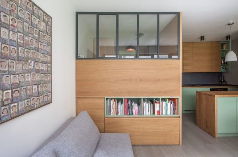 The living room consists of a grey sofa, a large storage unit that doubles as a space divider