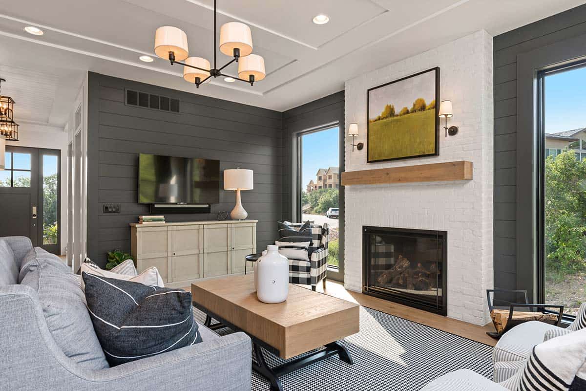 The living room is clad with bricks and shiplap, there's a fireplace and cool views