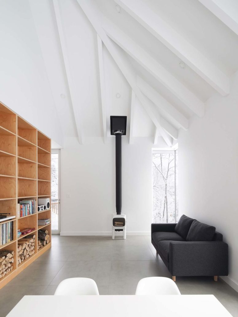 The living room is done with a grey sofa, a small fireplace and a large plywood storage units that doubles as a space divider