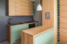 05 The kitchen features light-colored cabinets and minty green doors – everything necessary is here