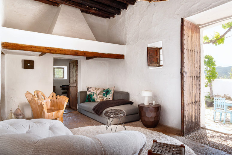 The living room is done with comfy neutral upholstered furniture, a wooden trunk chair and bright pillows