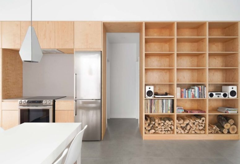 This storage unit continues to the kitchen and features sleek kitchen cabinets and built-in appliances