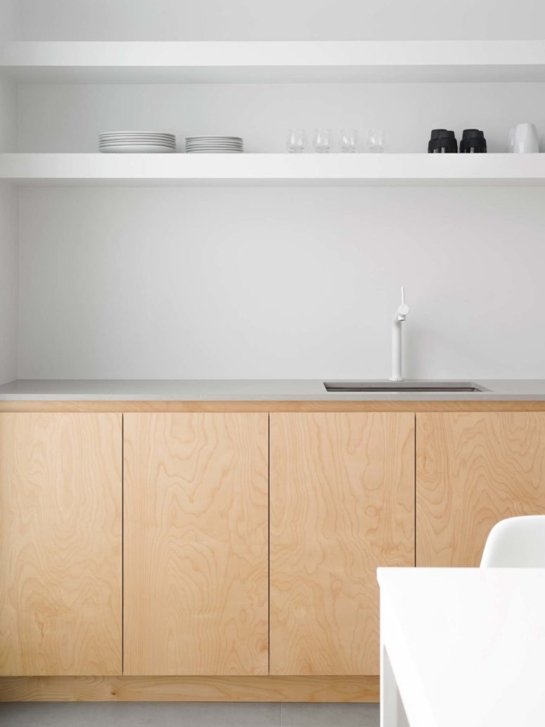 The backsplash is all-neutral,white appliances and concrete countertops perfectly fit the minimalist space