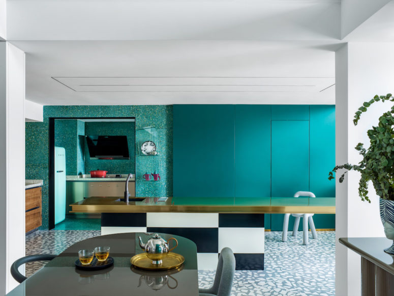 The kitchen makes a statement with a checked kitchen island with a gold countertop and all hidden cabinets and storage