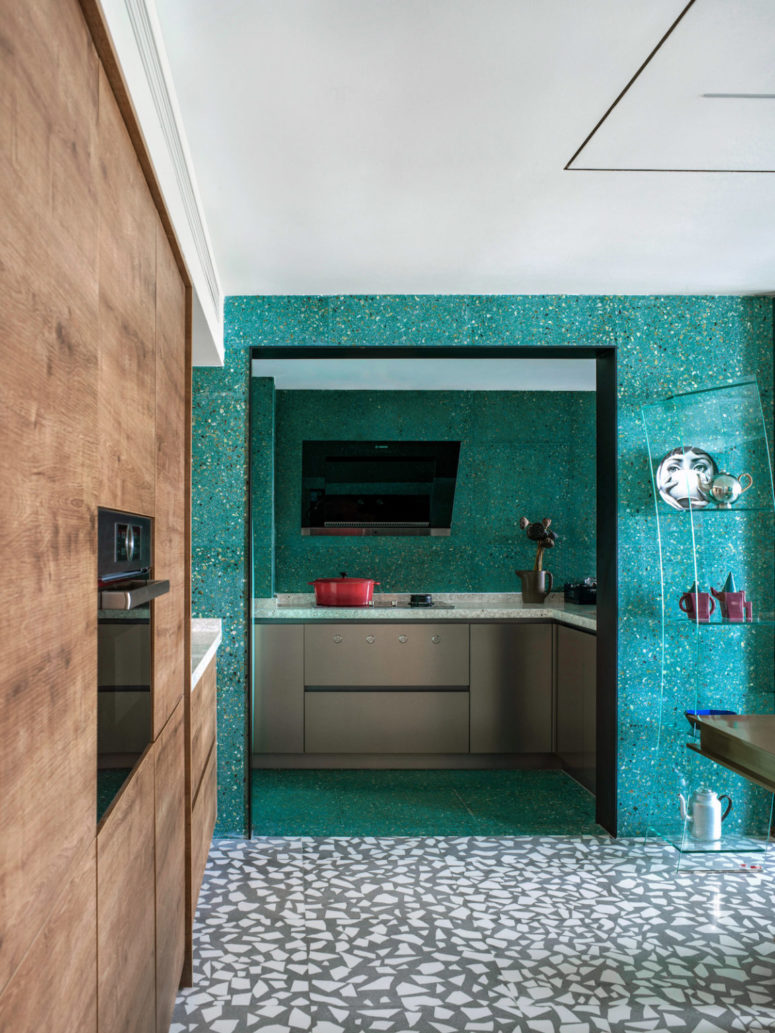 The cooking zone is pretty small, with a TV and simple grey cabinets with terrazzo countertops