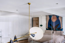 11 The bedroom features closed and sleek storage units, a floating bed, a bright artwork and hanging lamps