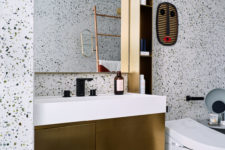 14 The gold vanity and a small shelf add to the look of the bathroom