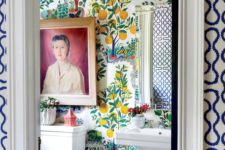 22 a super bold powder room with whimsy printed wallpaper, potted greenery and a bold artwork plus a striped lamp