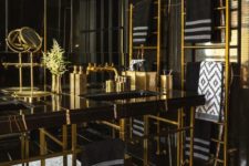 a bold art deco bathroom in black and gold, with marble, metal and lots of graphic touches here and there and gold accessories
