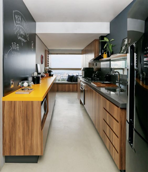 a contemporary black and yellow kitchen softened with light colored MDF cabinets and with black appliances