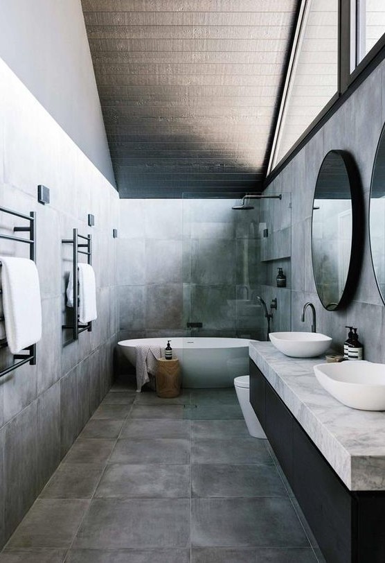 a grey bathroom with an attic ceiling, white appliances, a black and grey vanity and black fixtures