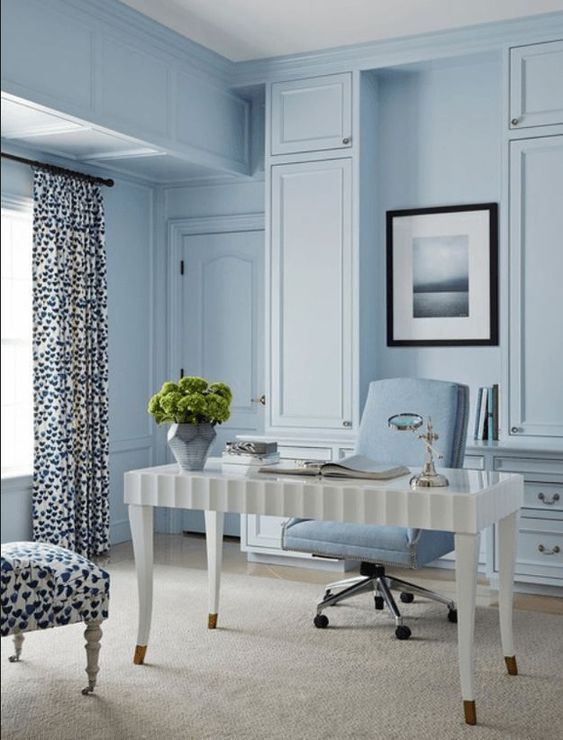 a light blue home office with a refined white desk, a powder blue chair, printed textiles and some greenery to refresh