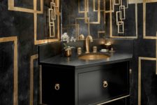 a luxurious black and gold bathroom with a geometric vanity, gold geometric detailing and gold fixtures and candles