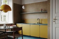 a minimalist blue and yellow kitchen with mid-century modern lamps and MDF cabinets plus a cognac ceiling