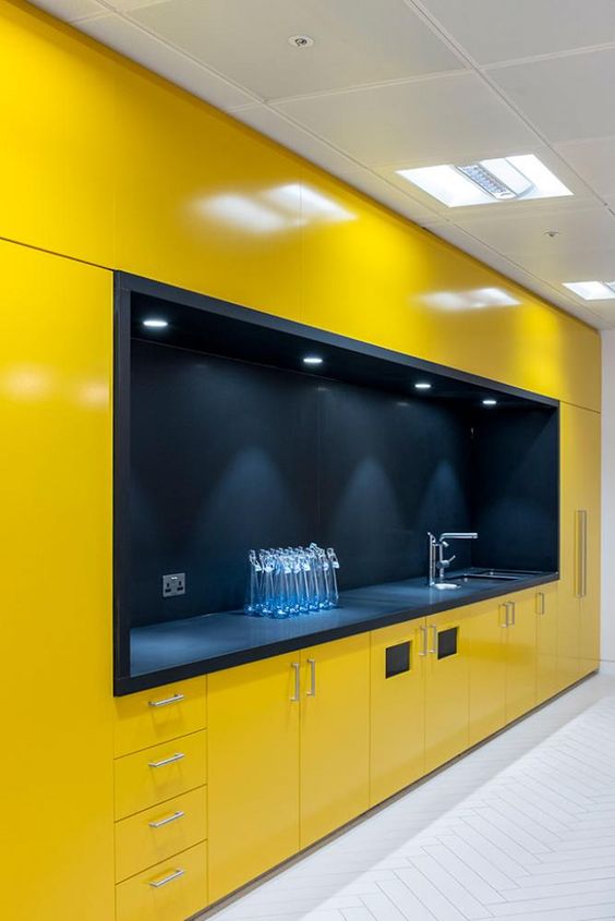 a minimalist yellow kitchen with everything hidden and a large black cooking space with built in lights looks amazing
