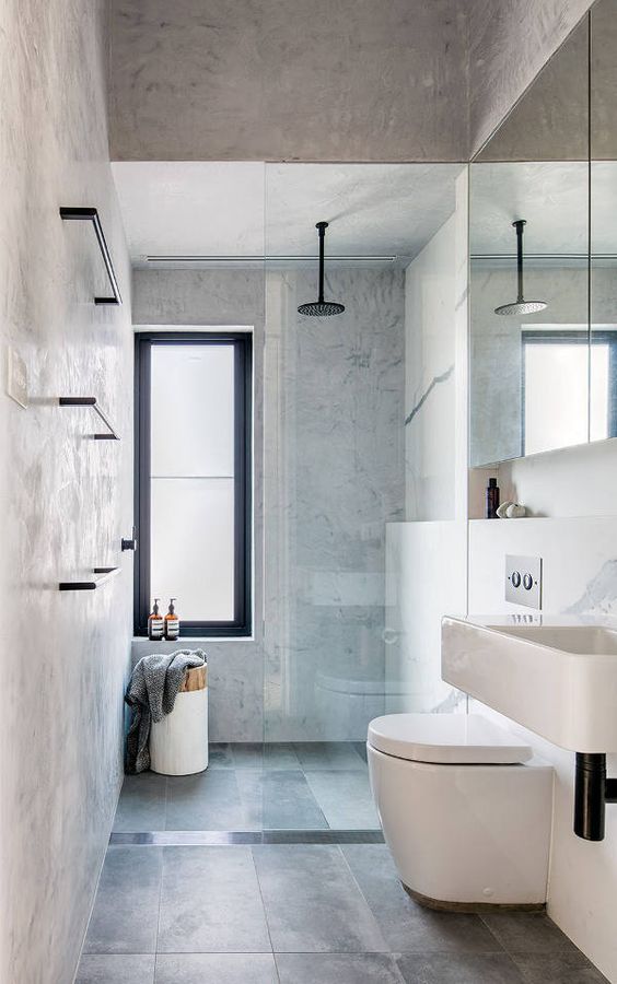 a minimalsit grey bathroom with grey walls and dark grey large scale tiles, a sink, a shower space and a mirror cabinet