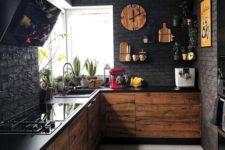 a moody black kitchen with faux brik walls, black countertops plus MDF cabinets and touches of yellow