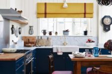 a navy and white kitchen with white stone countertops, a yellow curtain and brigth red chairs looks cool and eclectic