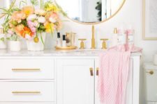 a pretty white bathroom with gold handles, gold framed mirrors and fixtures looks dreamy and very romantic