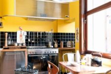 a retro kitchen done in bright yellow and black, with chic mid-century modern furniture and touches of warm stained wood