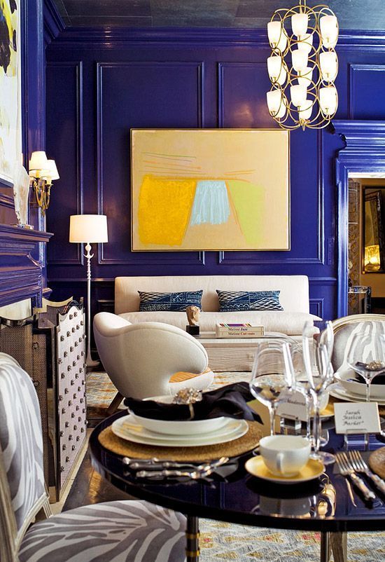 a super bold, whimsy and luxurious living room with bold blue paneled walls that make a color statement at once